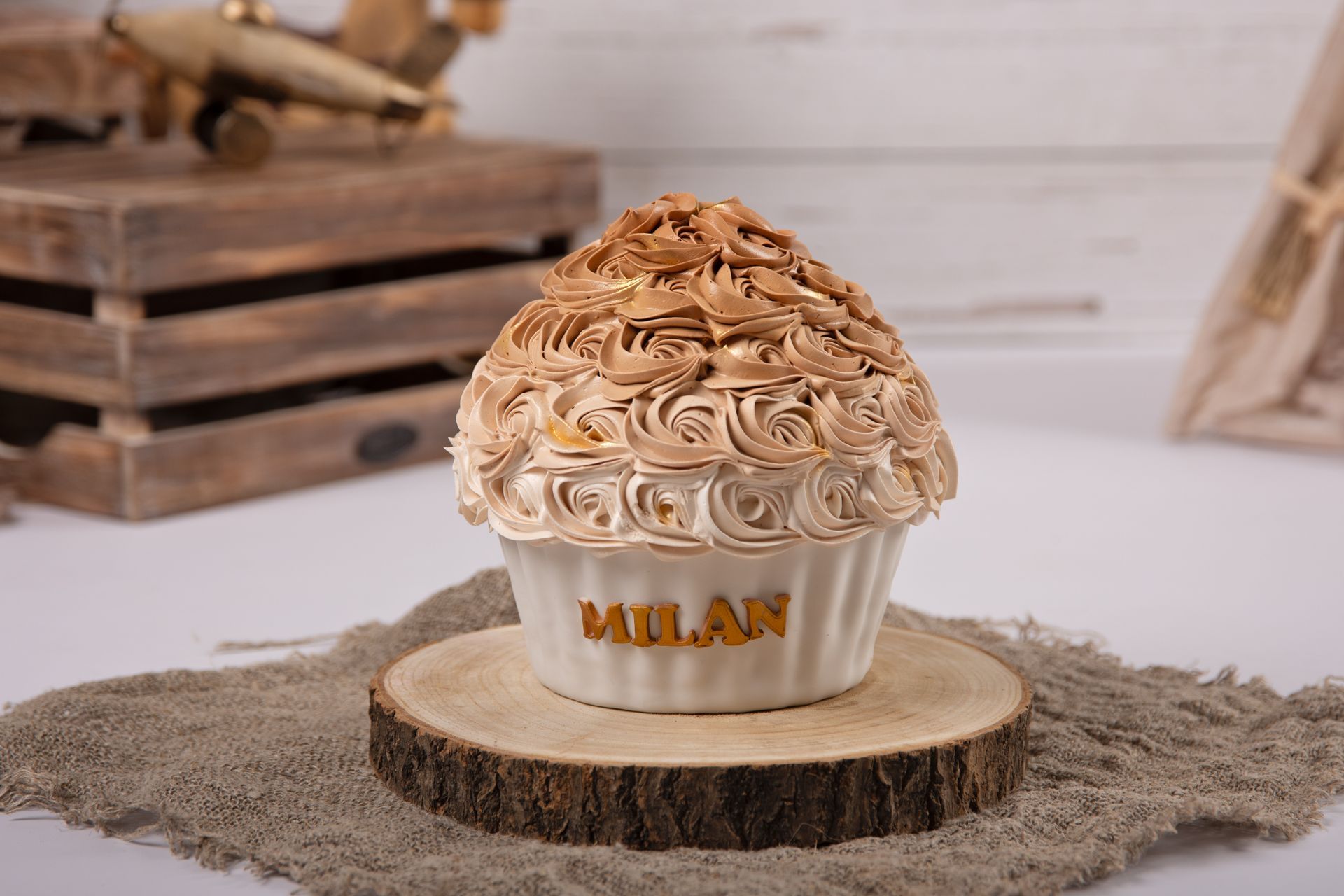 Een cupcake met de naam Milaan erop staat op een houten stronk.