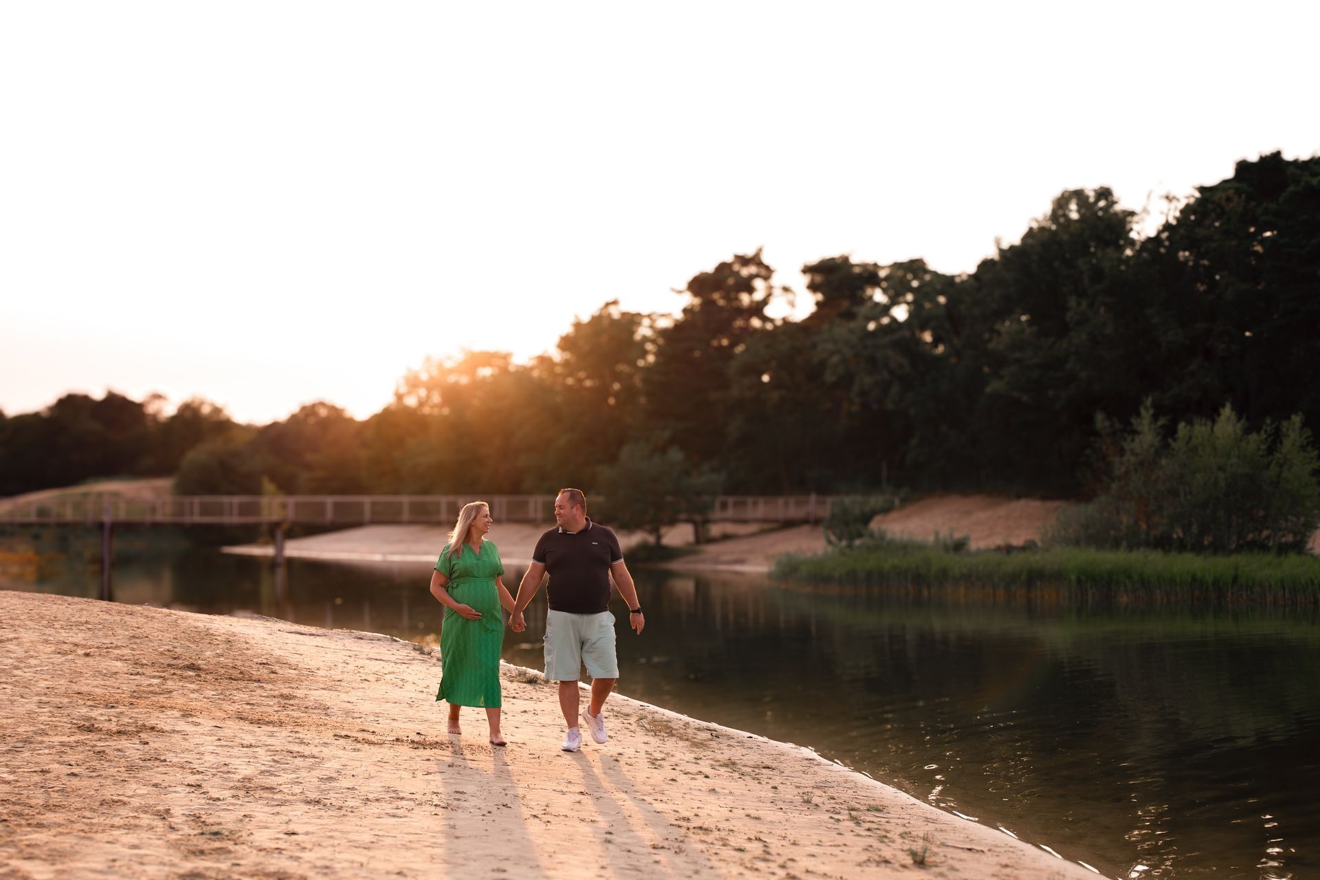 Een man en een vrouw lopen hand in hand over het strand.