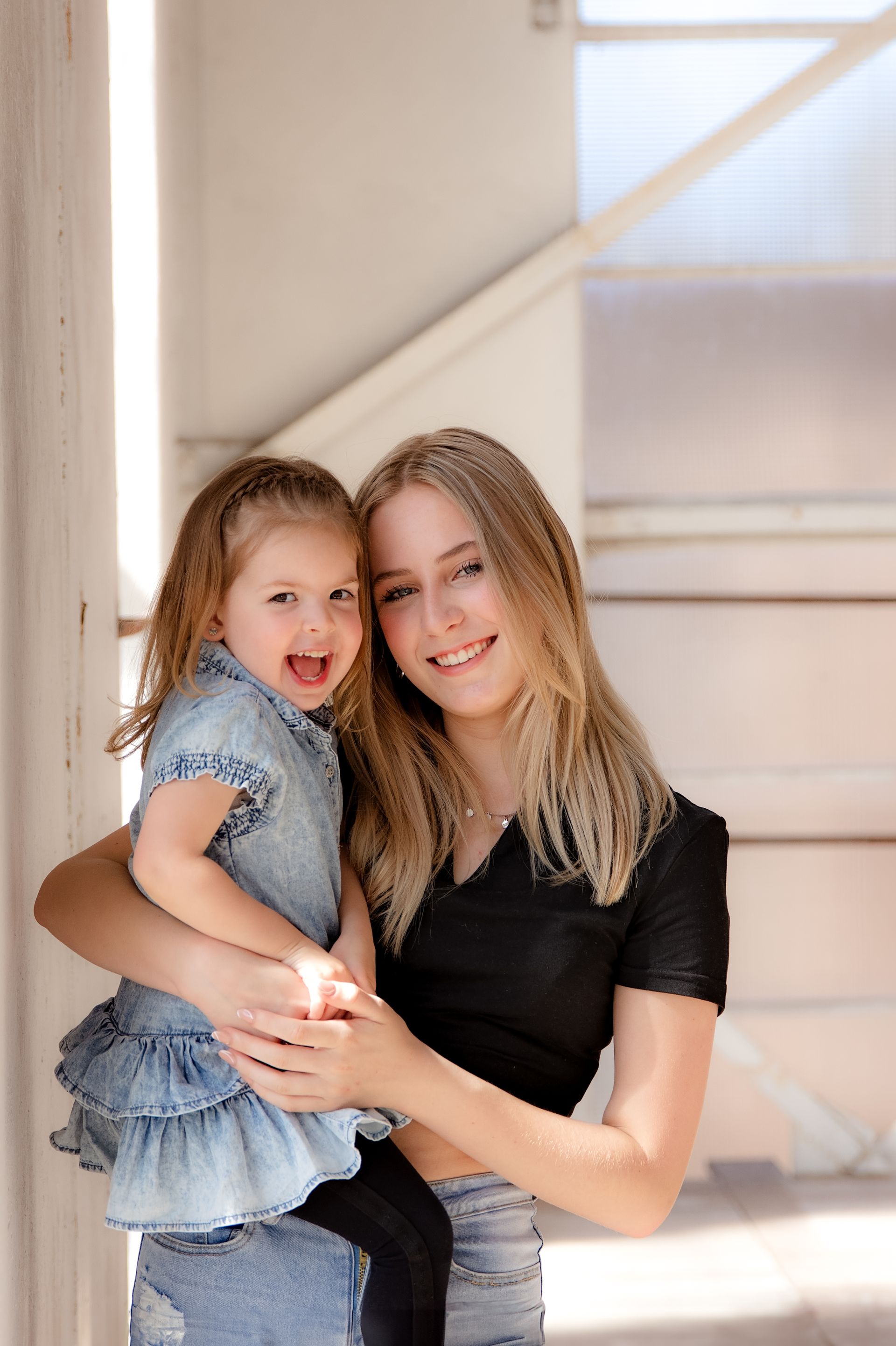 Een vrouw houdt een klein meisje in haar armen.