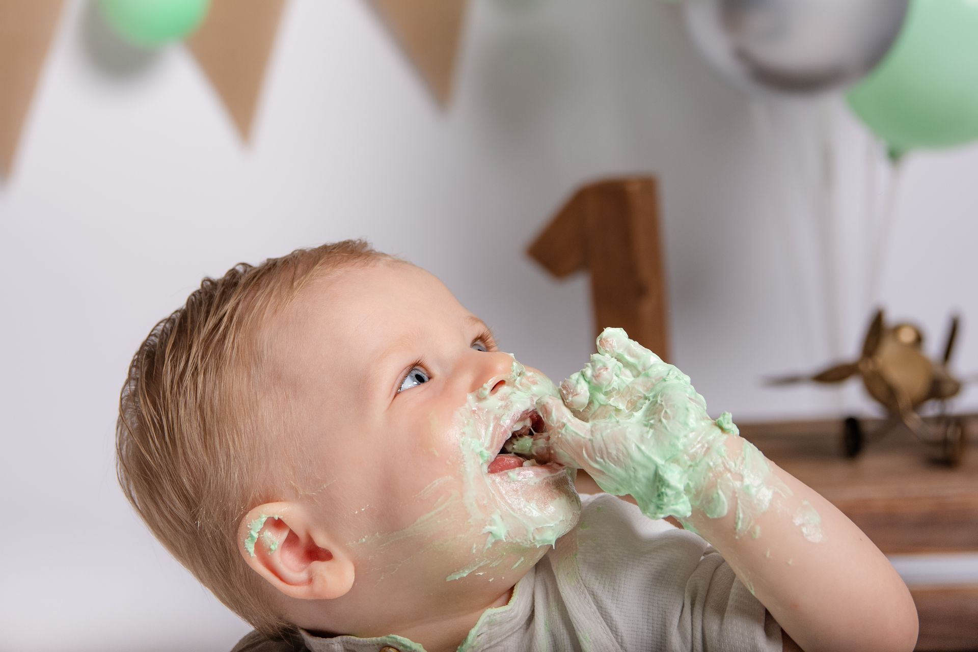 Een baby eet taart met zijn handen bedekt met glazuur.