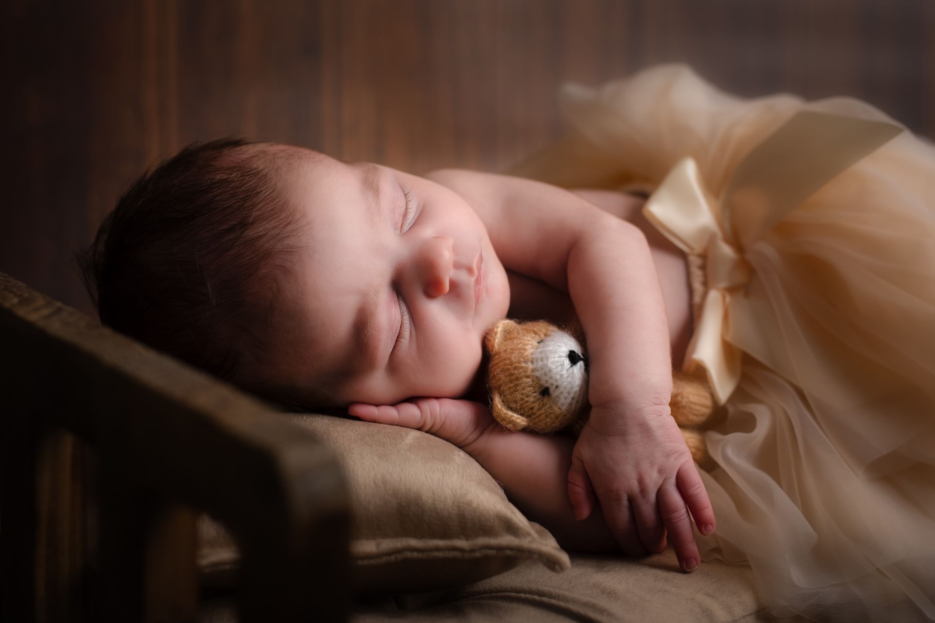 Een pasgeboren baby slaapt met een teddybeer.