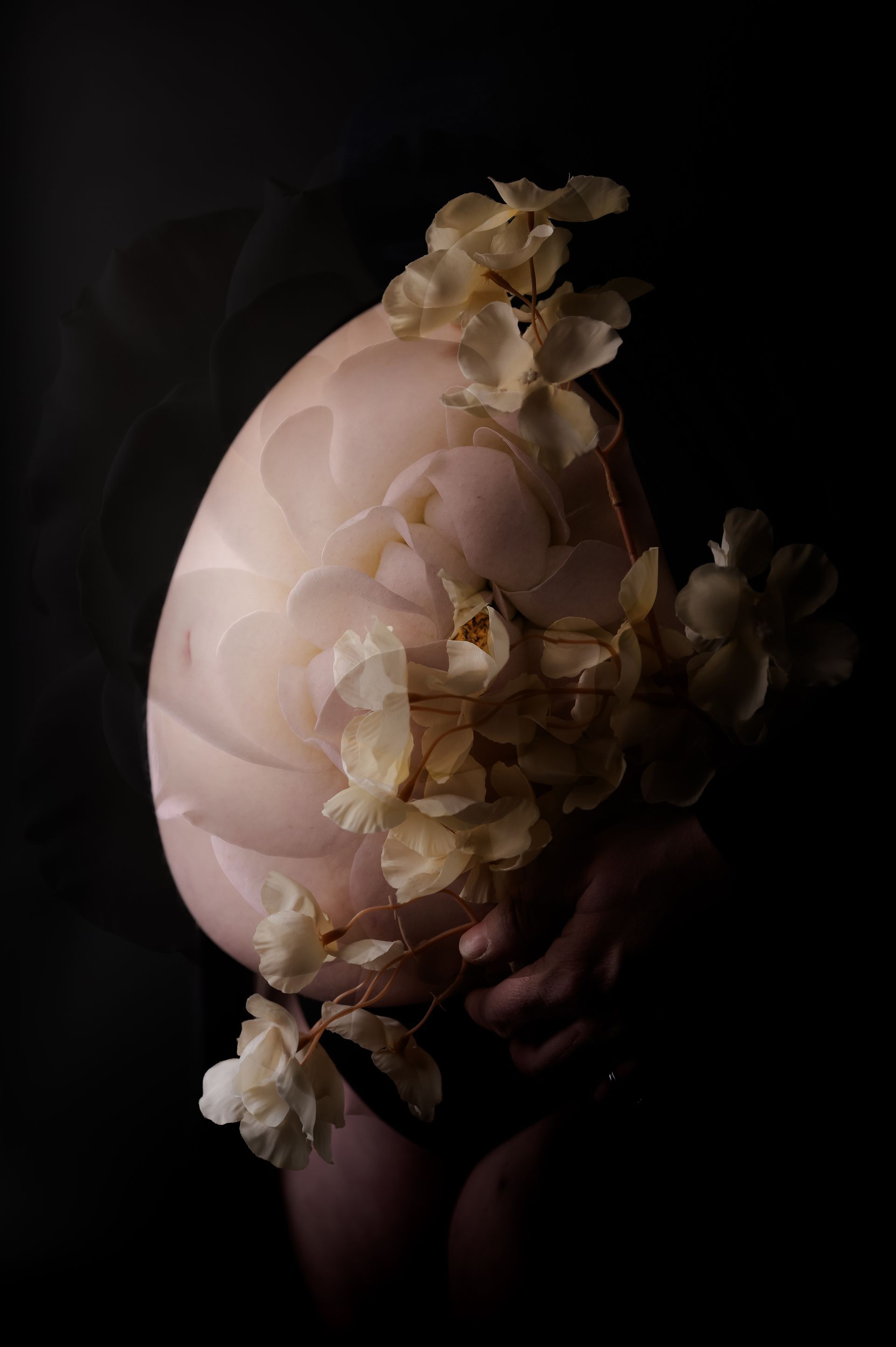 Een vrouw houdt een groot ei vast met bloemen erop.