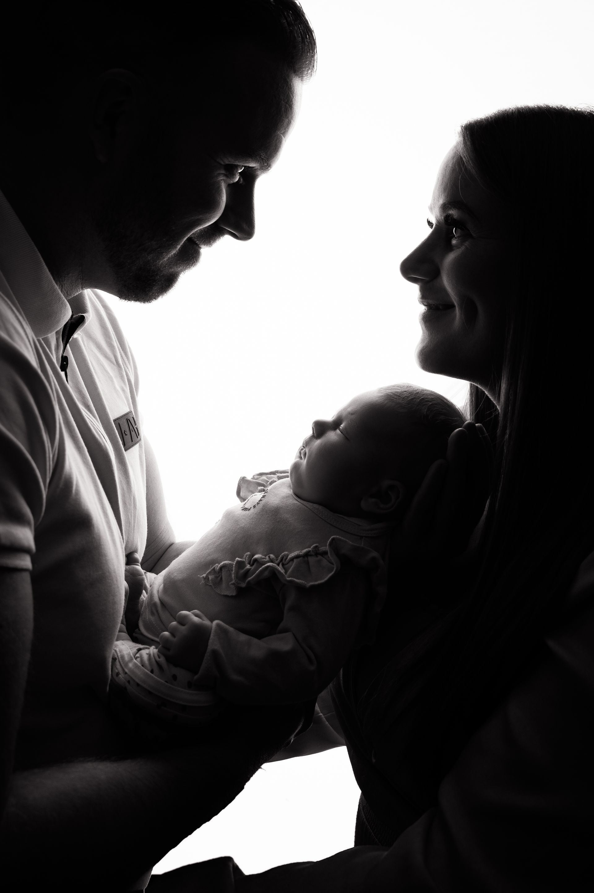 Een man en een vrouw houden een baby in hun armen.