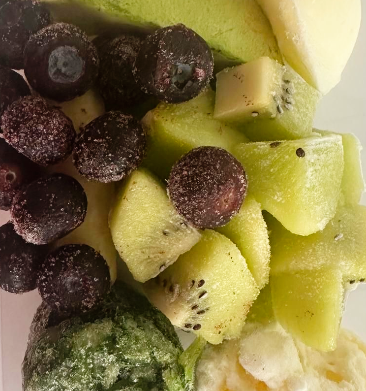 Frozen blueberries, kiwi, avocado, and banana pieces, close-up.