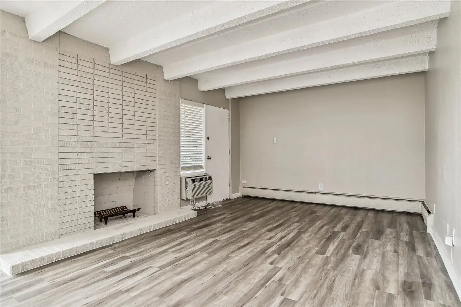 Living room with a fireplace and wood-look flooring.