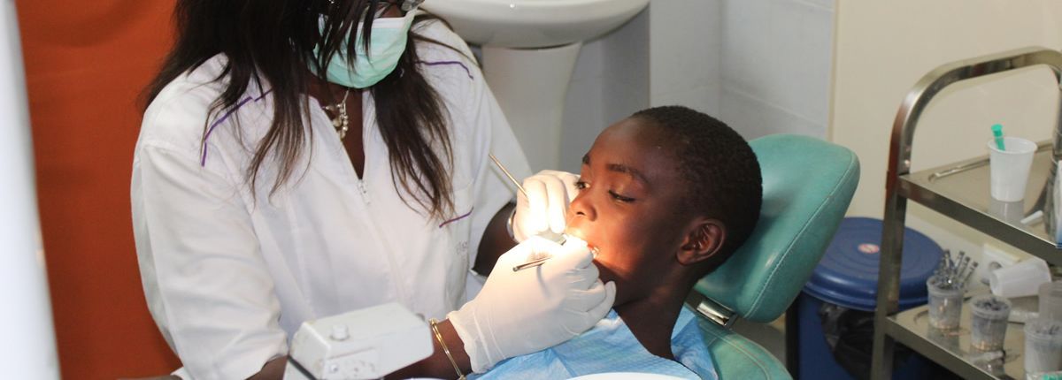 A young boy is getting his teeth examined by a dentist