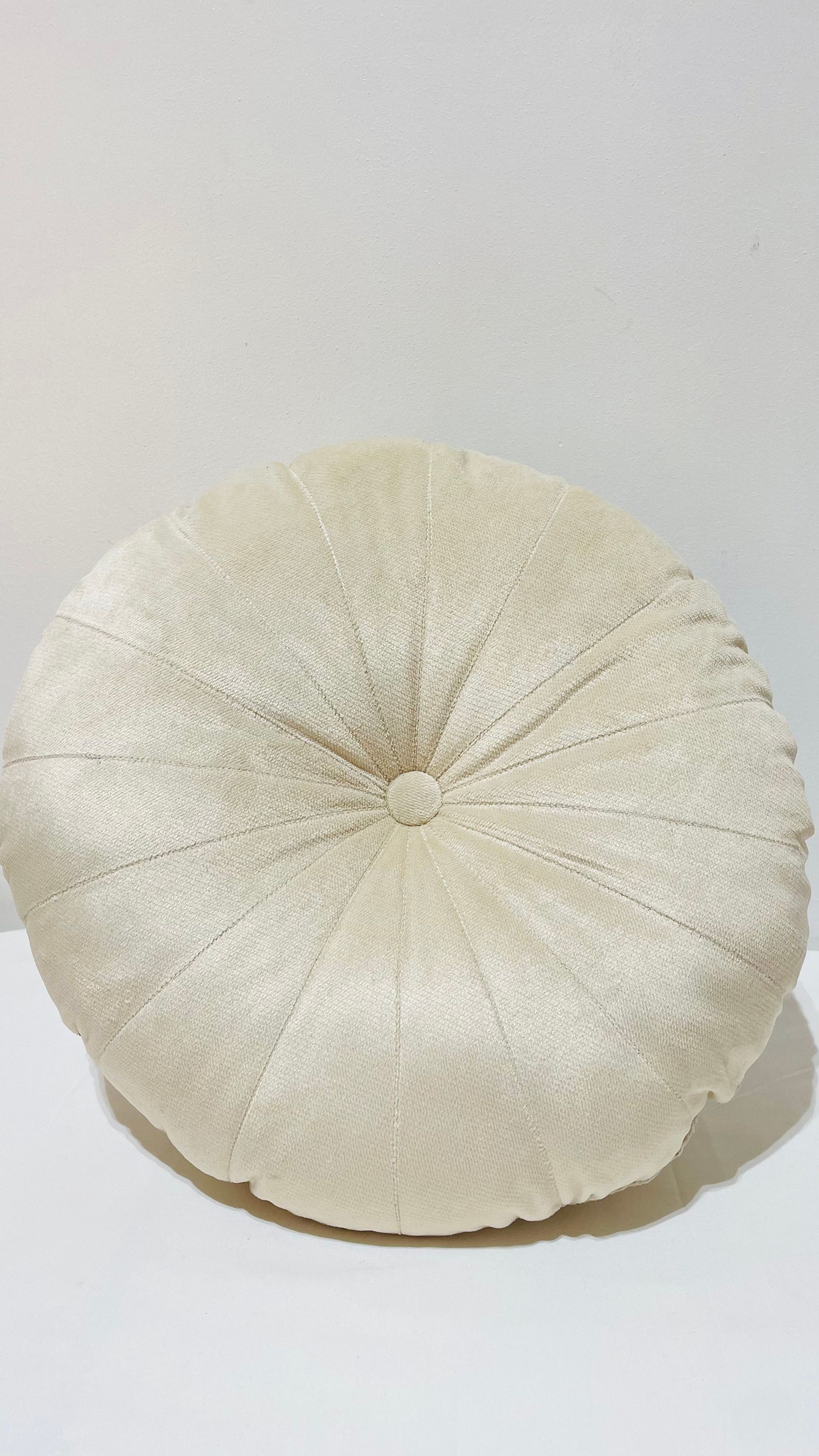 Un oreiller blanc est posé sur une table blanche.