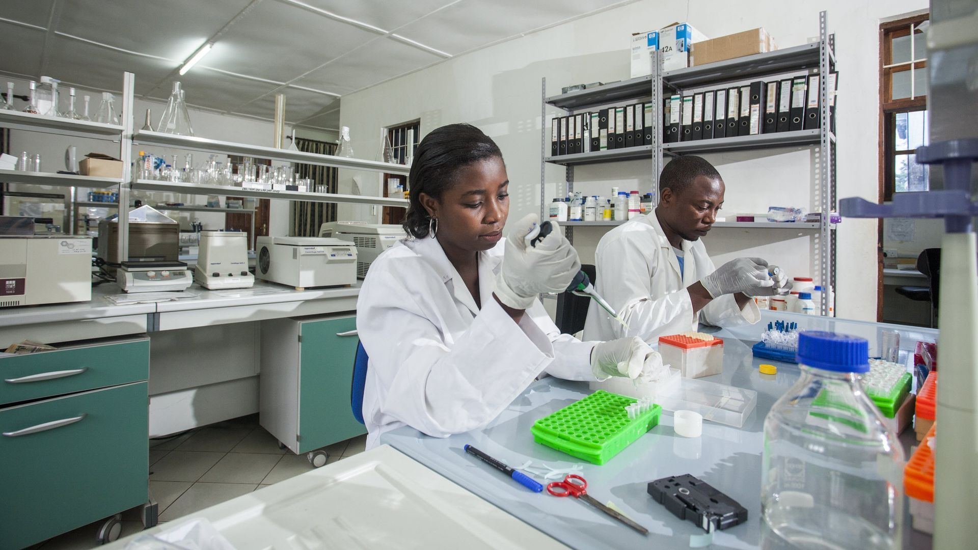A man and a woman are working in a lab.
