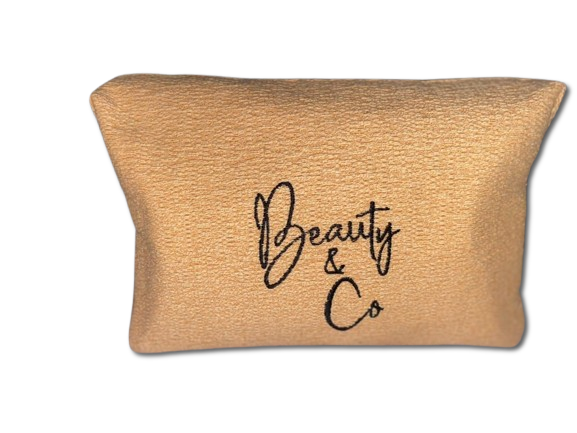 Une trousse de maquillage marron avec les mots « beauty & co » brodés dessus.