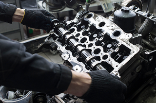 Mechanic examining engine of vehicle | Iberia Discount Tire
