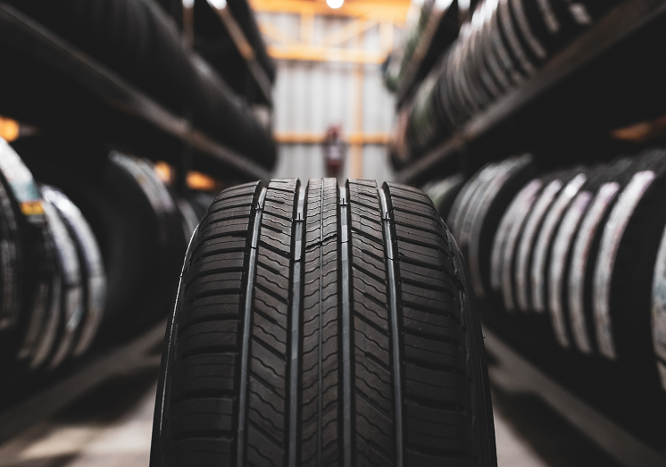 Rows of tires in garage, with a tire lined up in the center | Iberia Discount Tire