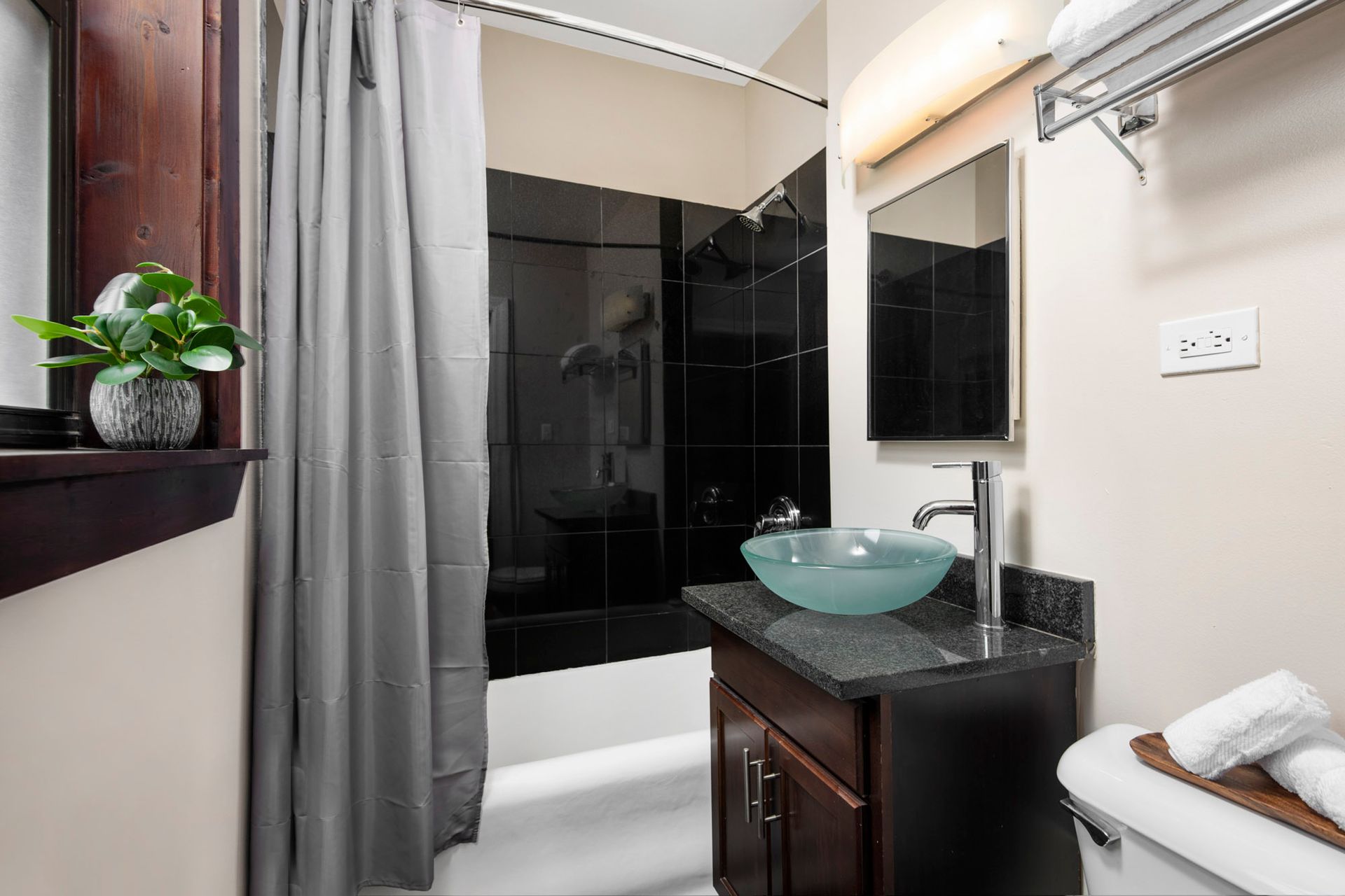 A bathroom with a sink, tub, mirror, and shower curtain at Reside at Belmont Harbor. 