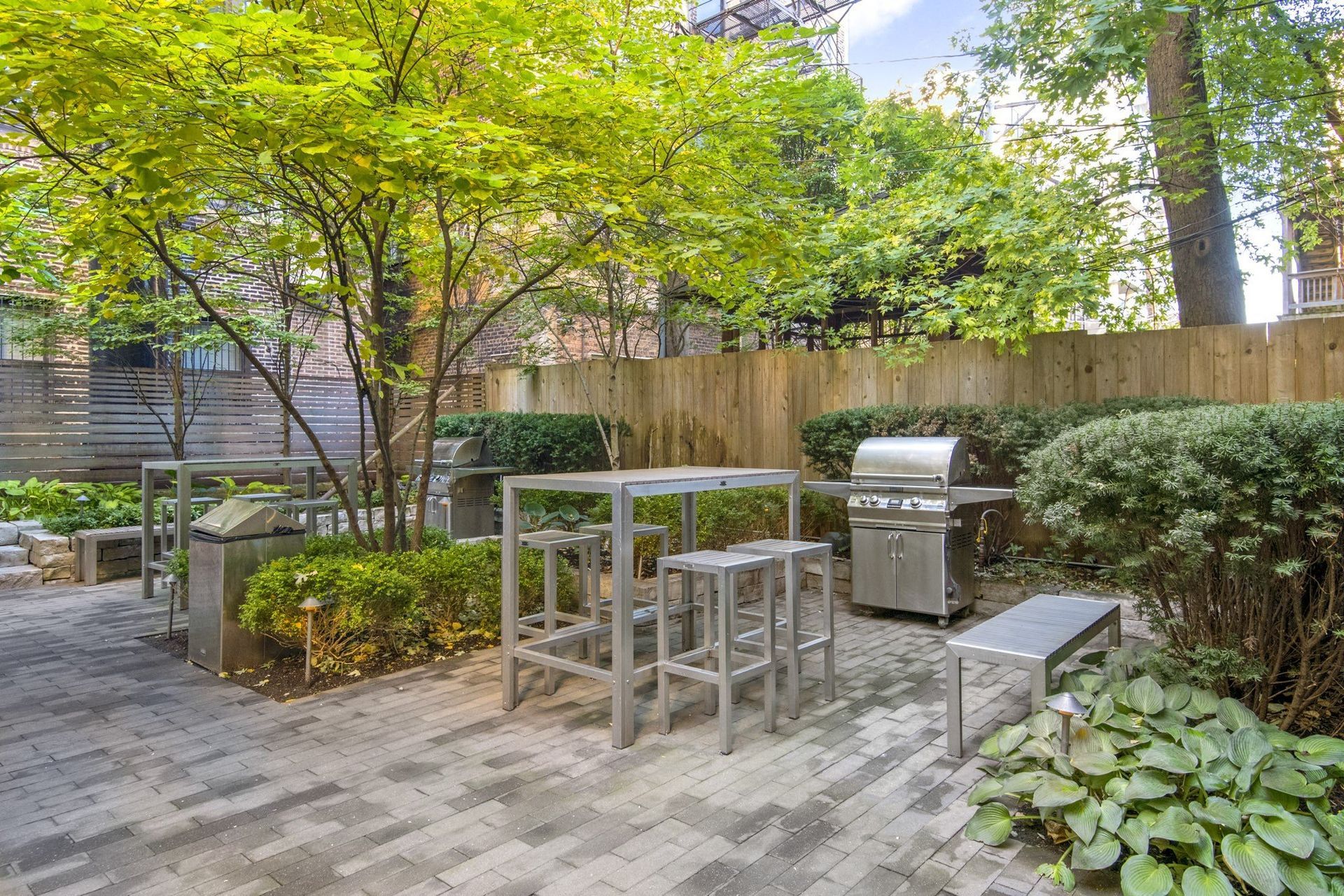 a small patio with tables and chairs and a grill