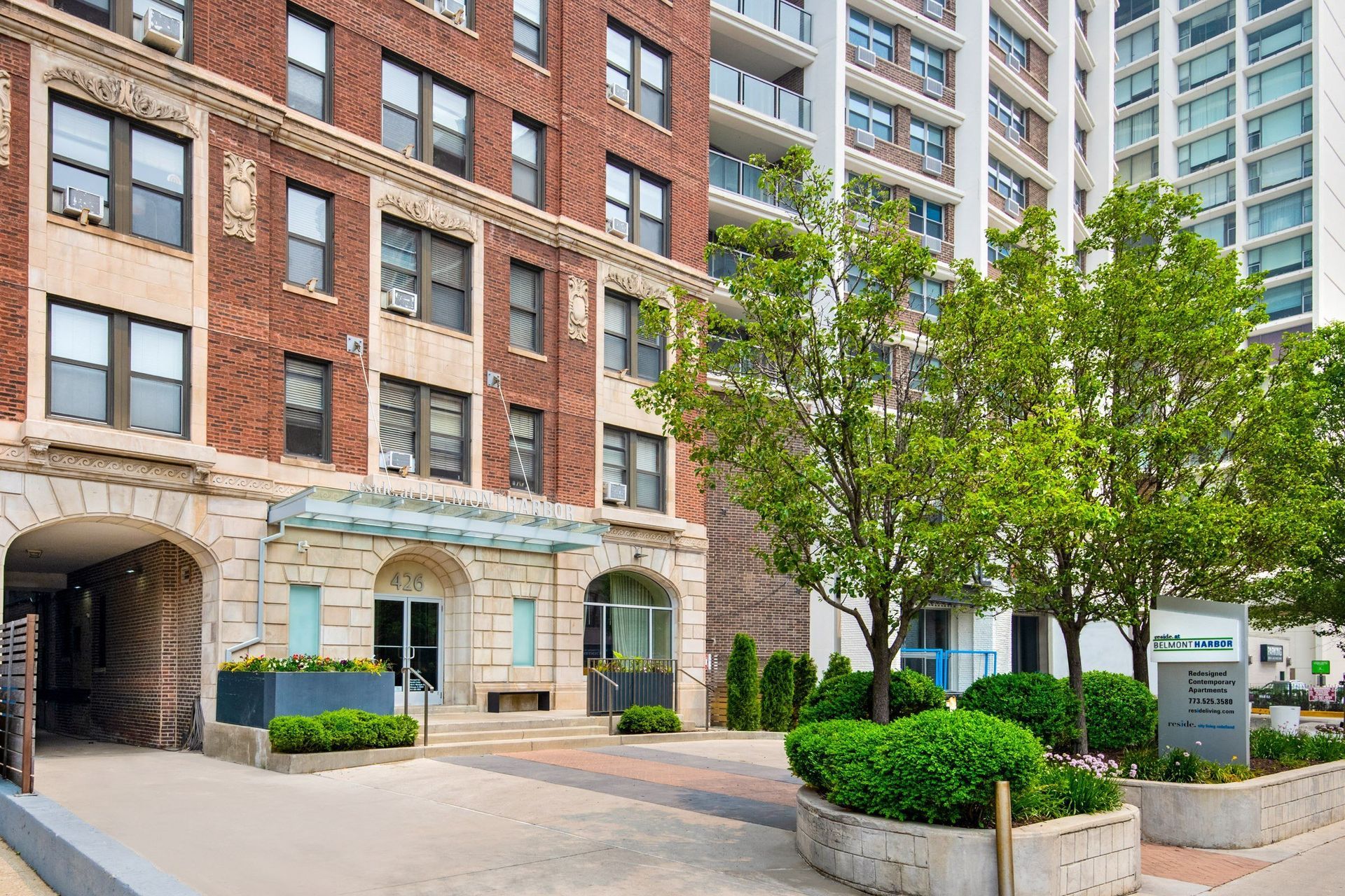 an apartment building with a courtyard and trees in front of it