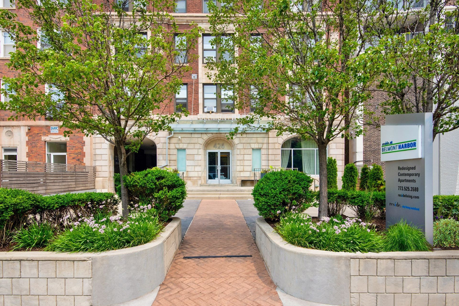 the front of a building with a walkway and trees