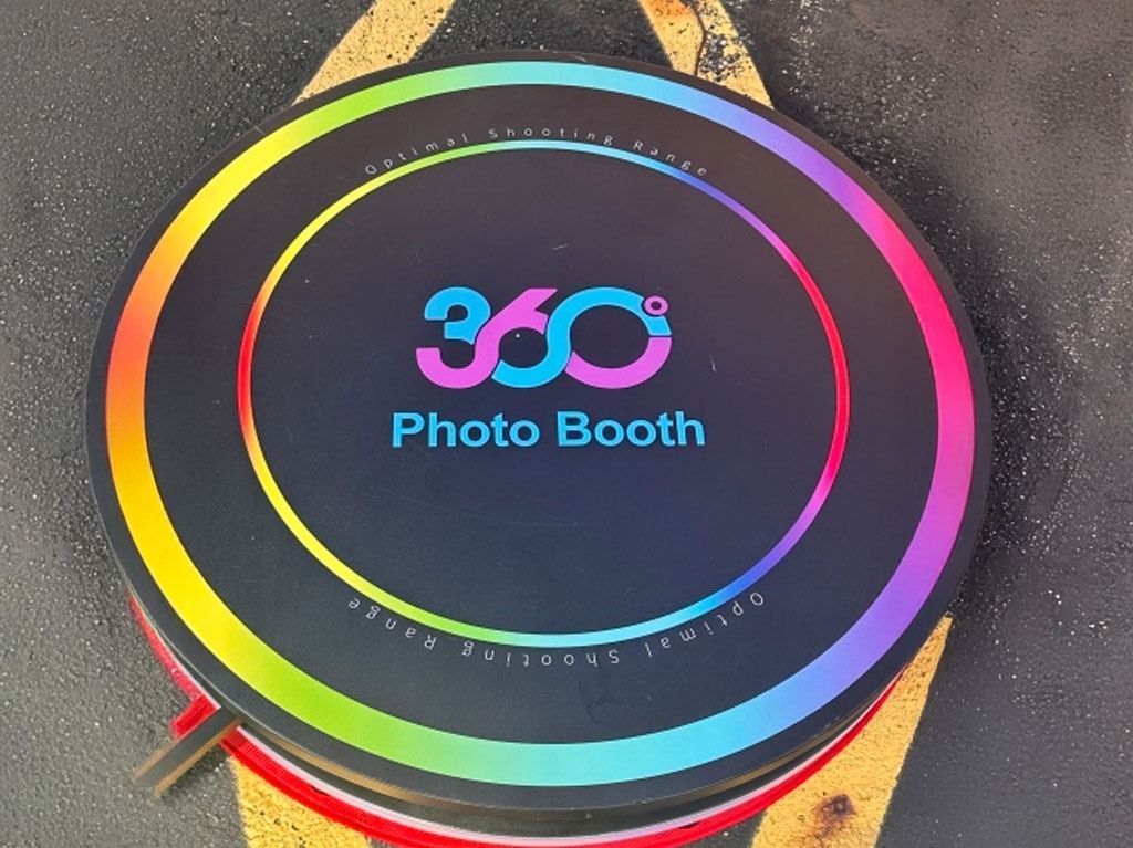 360 Photo Booth with a rainbow LED ring and logo on a black platform.