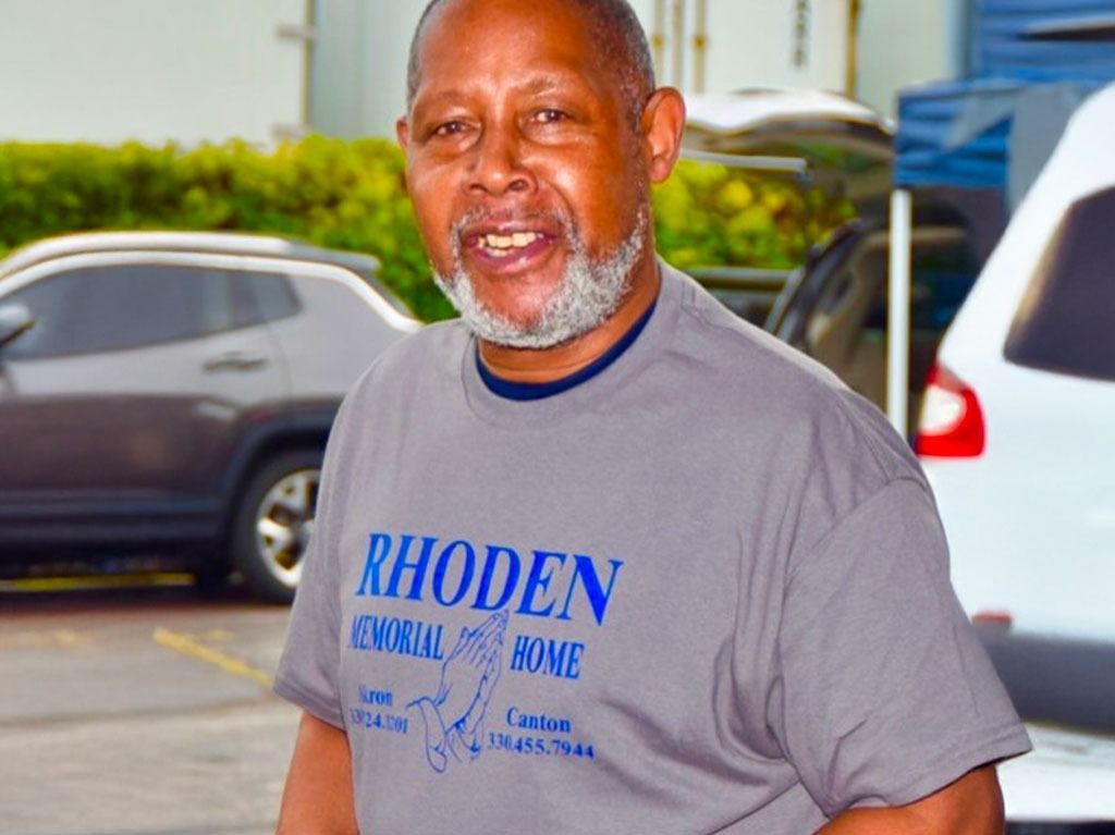 Man with gray beard wearing a gray shirt that says