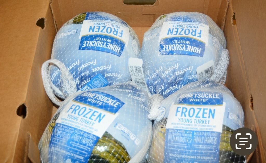 Four frozen Honeysuckle White turkeys in a cardboard box.