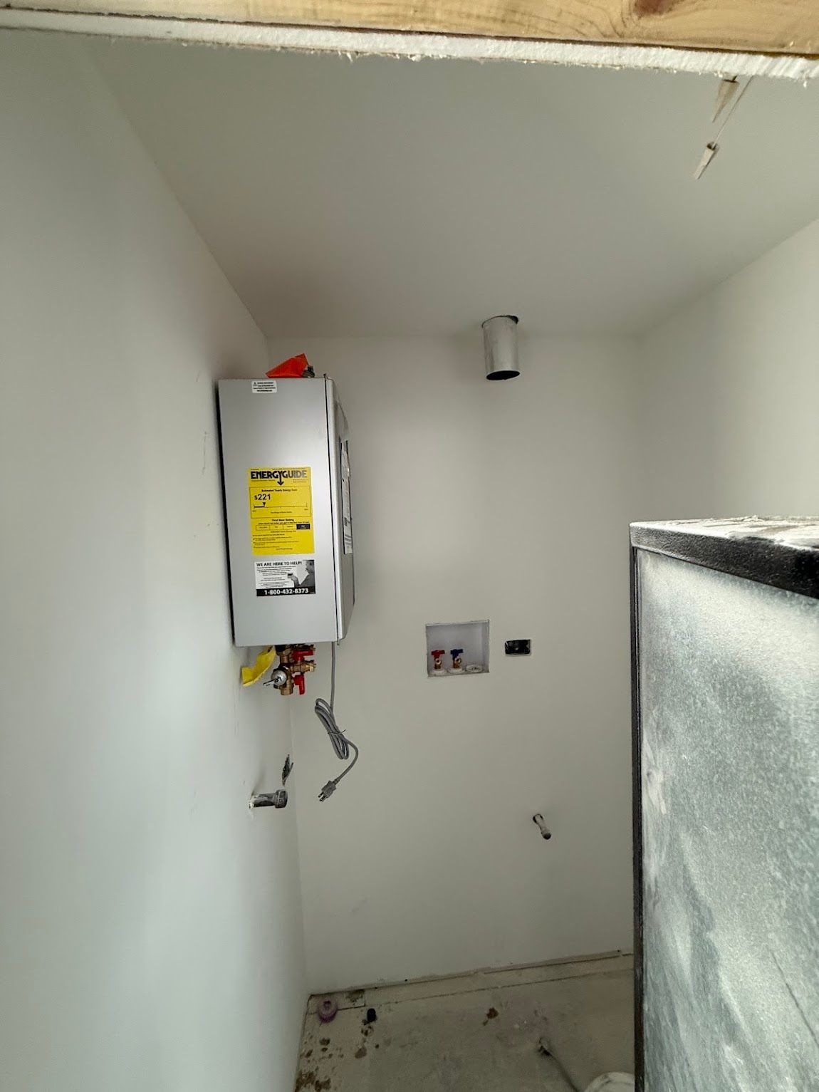 Small utility closet with a wall-mounted electrical panel, exposed wires, and insulation on the right.
