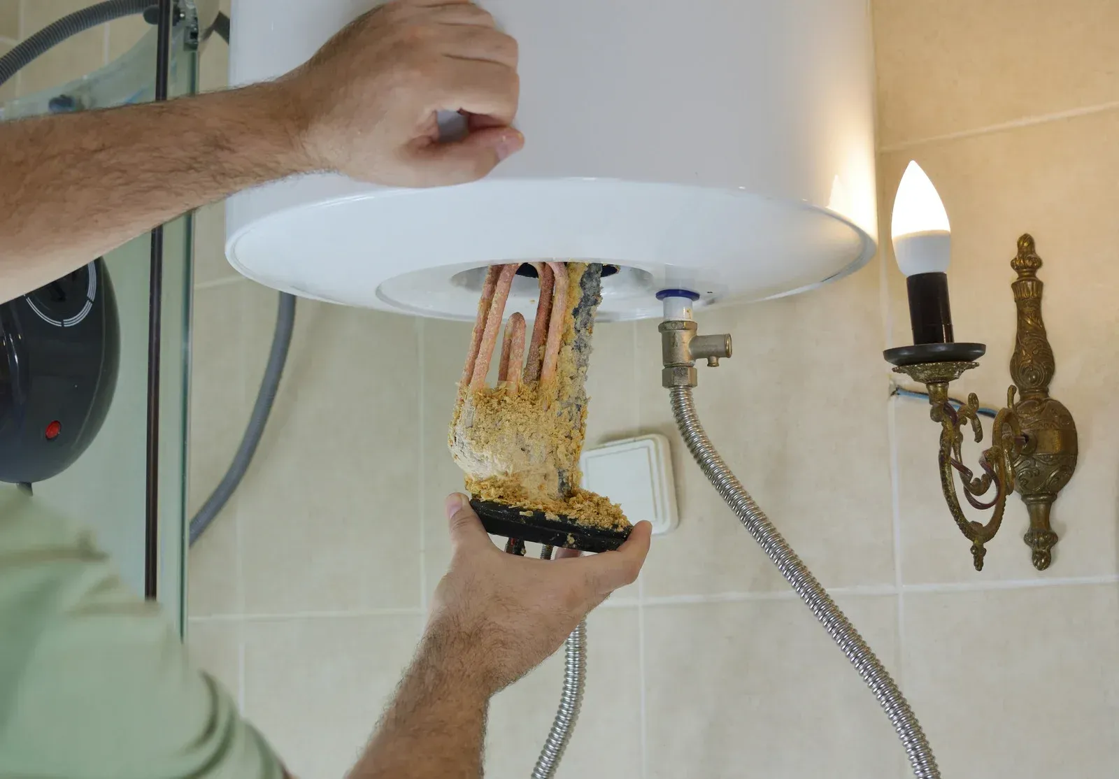 Hand holding a showerhead while a brush cleans tangled hair under it in a bathroom