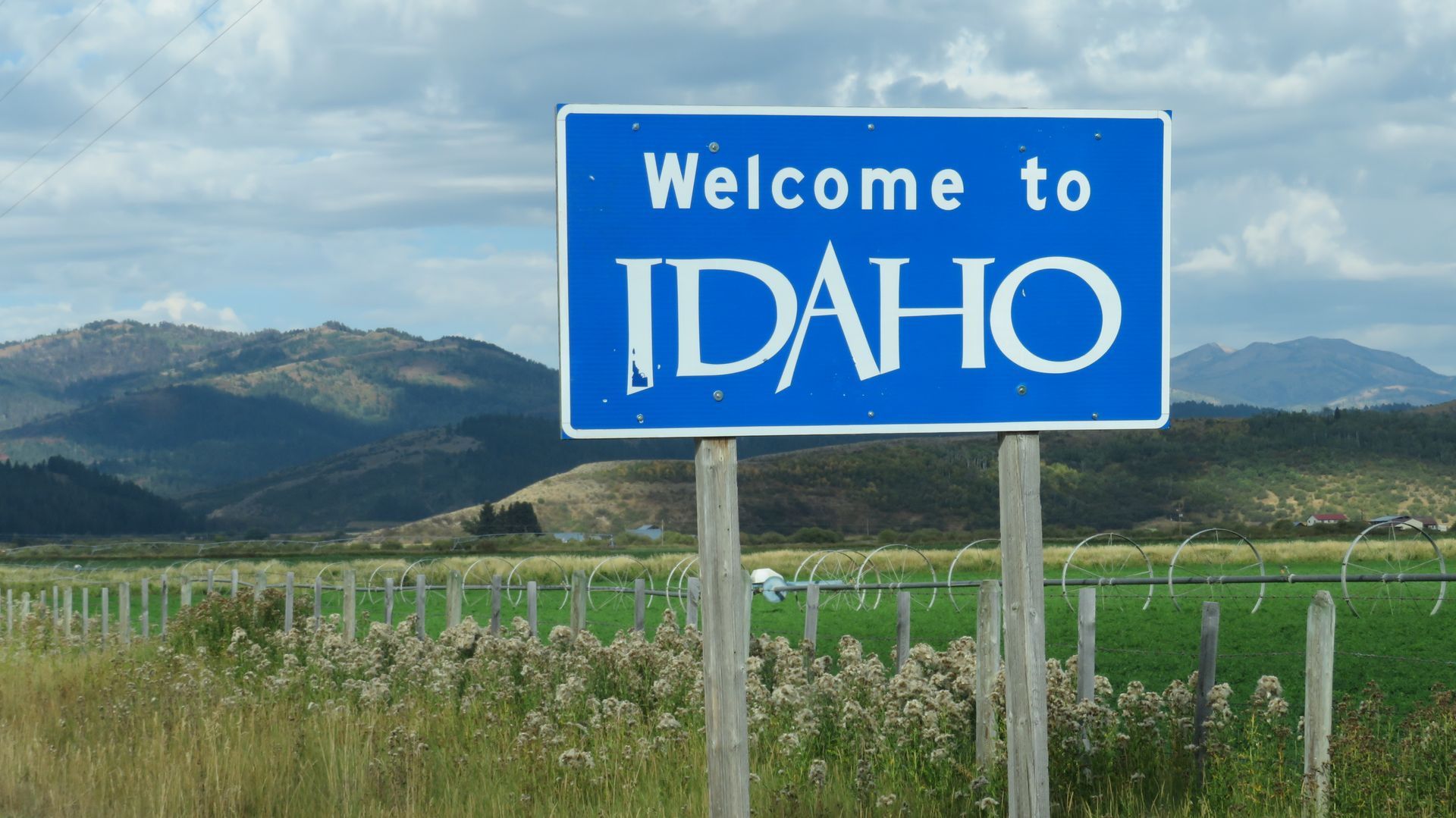 Welcome to Idaho sign against a mountain backdrop.