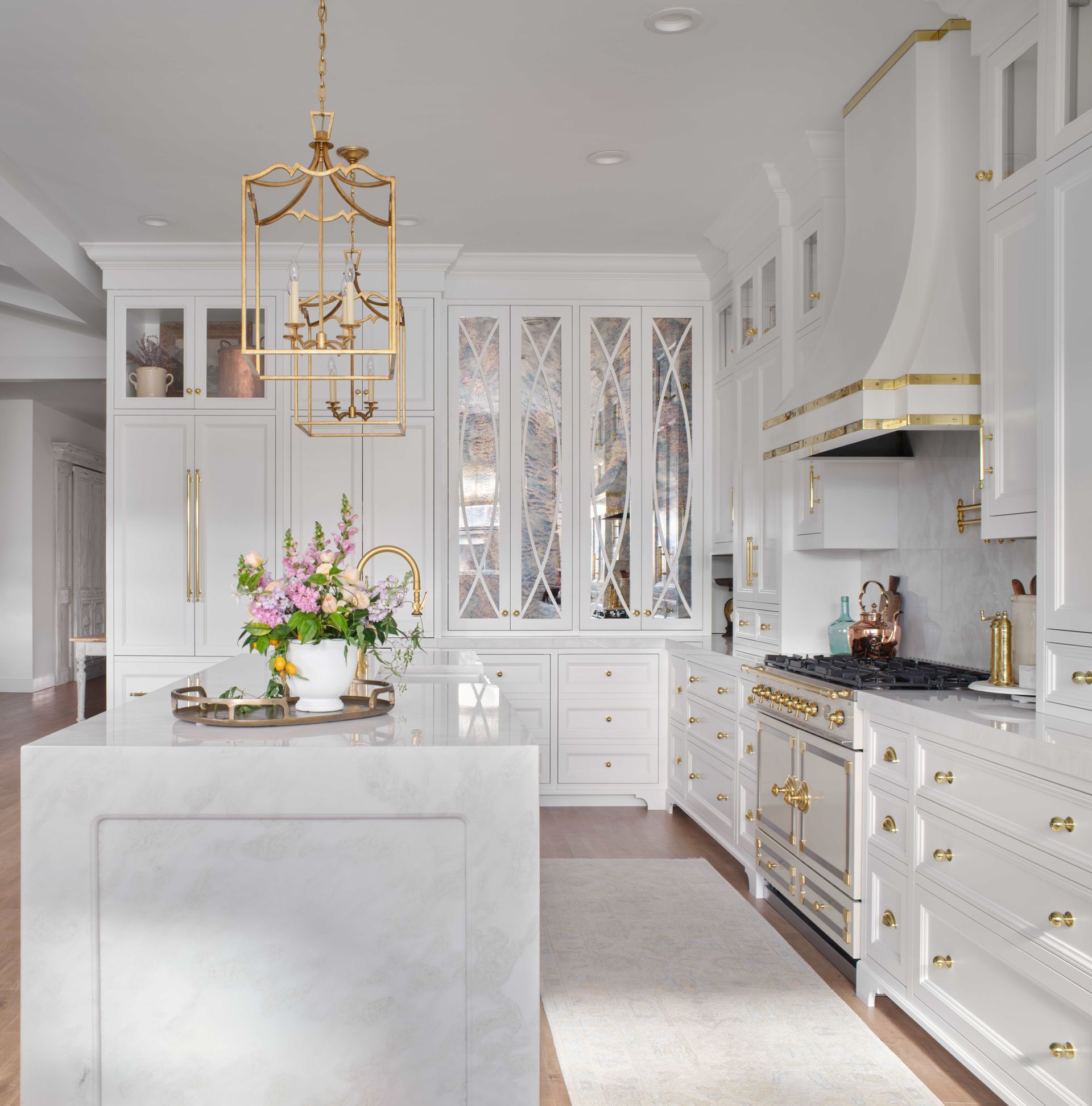 A kitchen with white cabinets and a large island