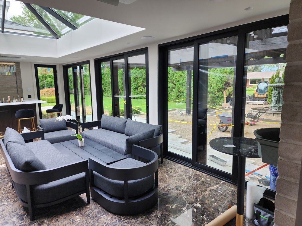 A living room with a lot of windows and furniture.