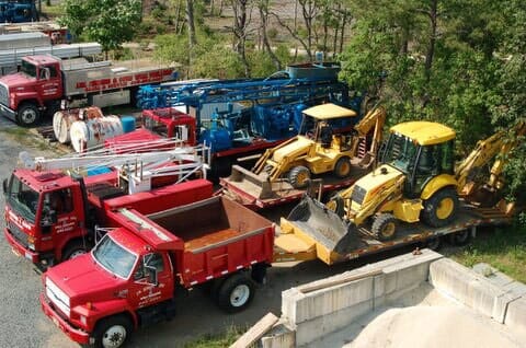 Two Red Trucks Pulling CATs - Well Drilling in Browns Mills, NJ