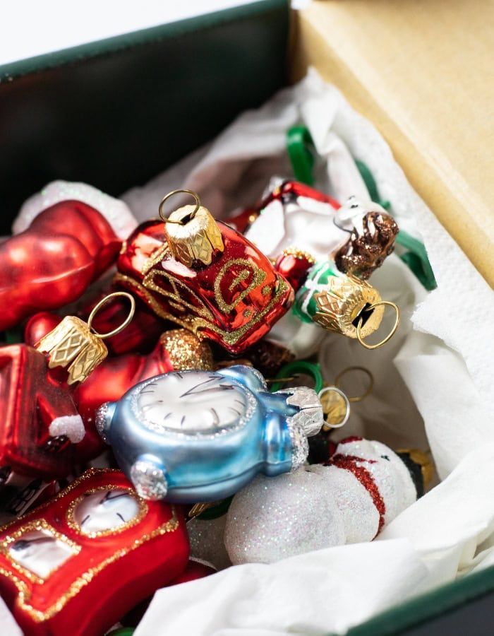 Plastic storage bins with holiday decorations labeled by season, stacked neatly for seasonal storage