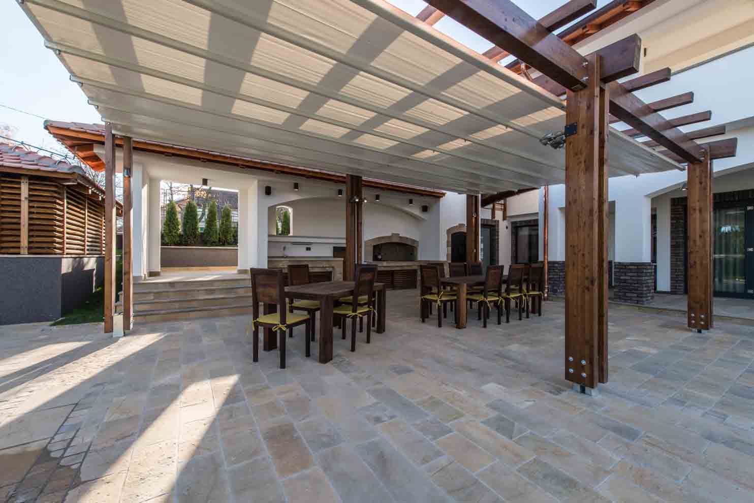 Long table and chairs on veranda in luxury villa exterior