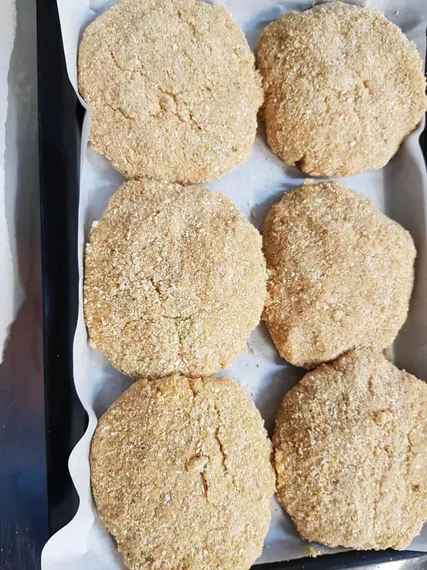 Six Breaded Patties on Parchment Paper in A Baking Pan — Glenmore Seafoods In Park Avenue, QLD
