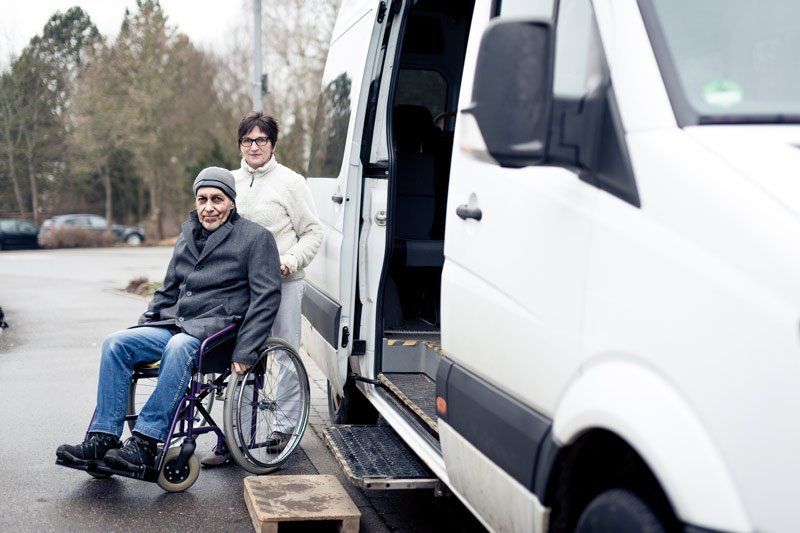 Man in hat getting onto awheelchair van man in hat getting onto a wheelchair van