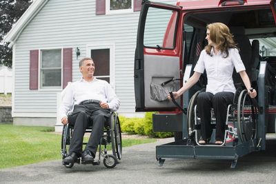 lady coming down from wheelchair lift while man in wheel chair watches