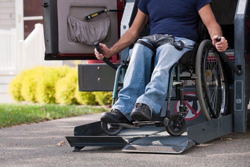 man getting wheelchair out of van
