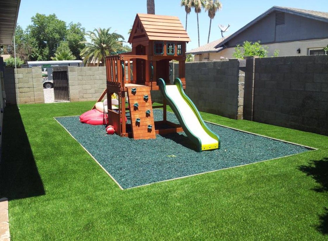 A backyard with a wooden playground and a slide