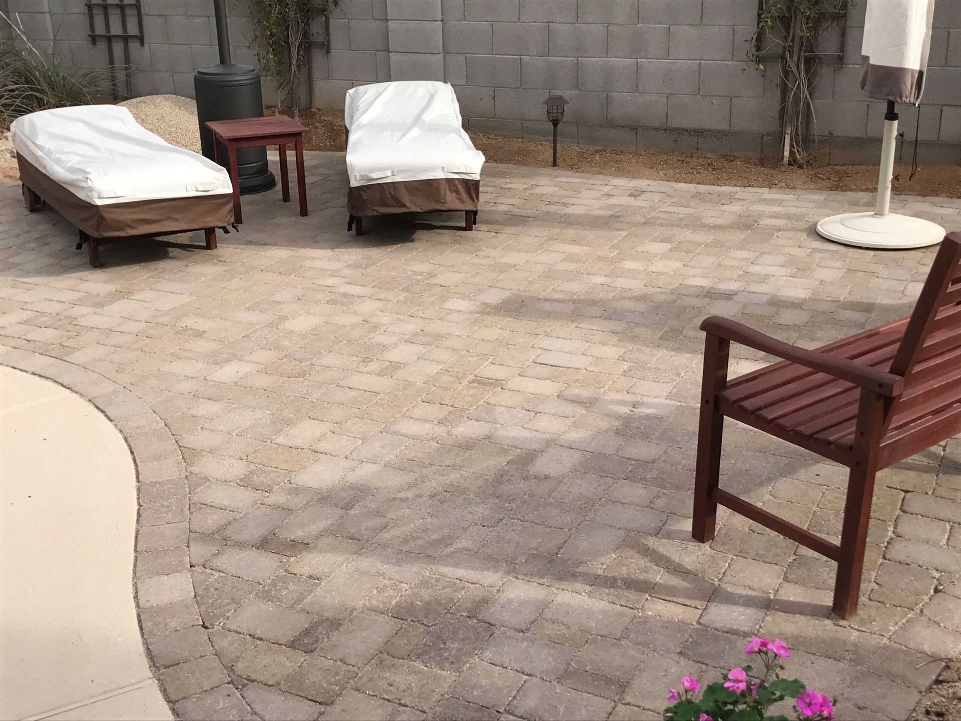 A patio with chairs , tables and an umbrella