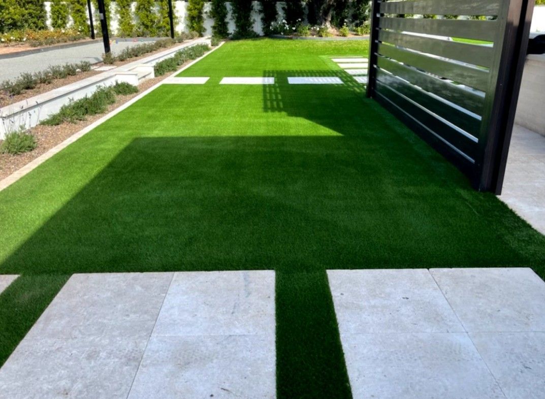 A yard with a lot of green grass and a fence.