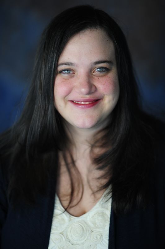 Woman in red shirt smiling, holding a 