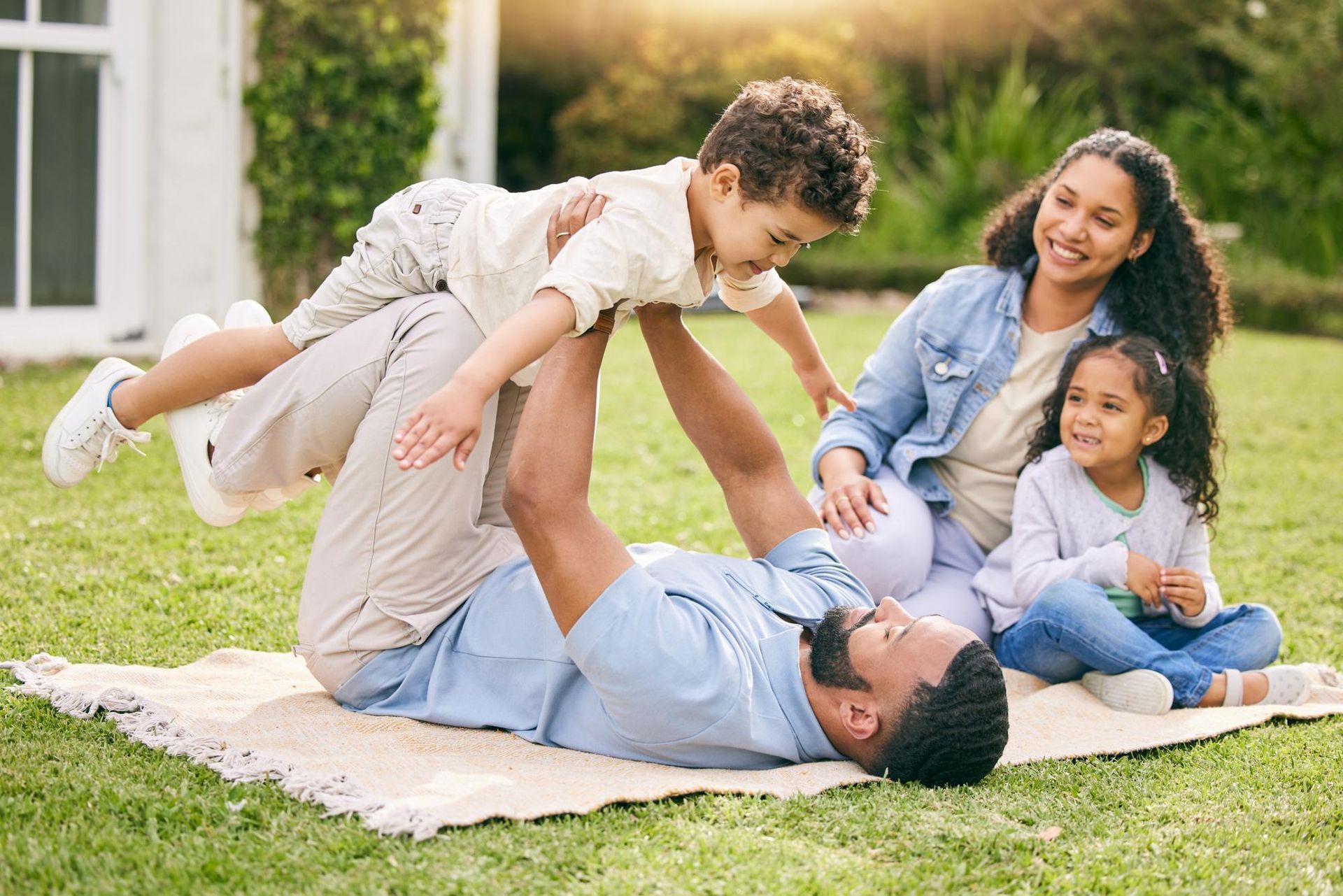 A family is sitting at a table looking at a laptop computer.