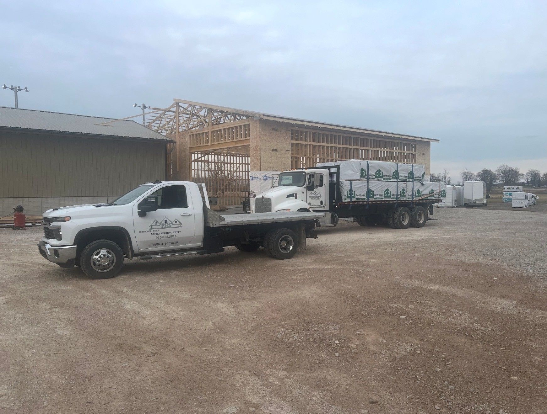 A delivery man is giving a package to a woman in front of a van.