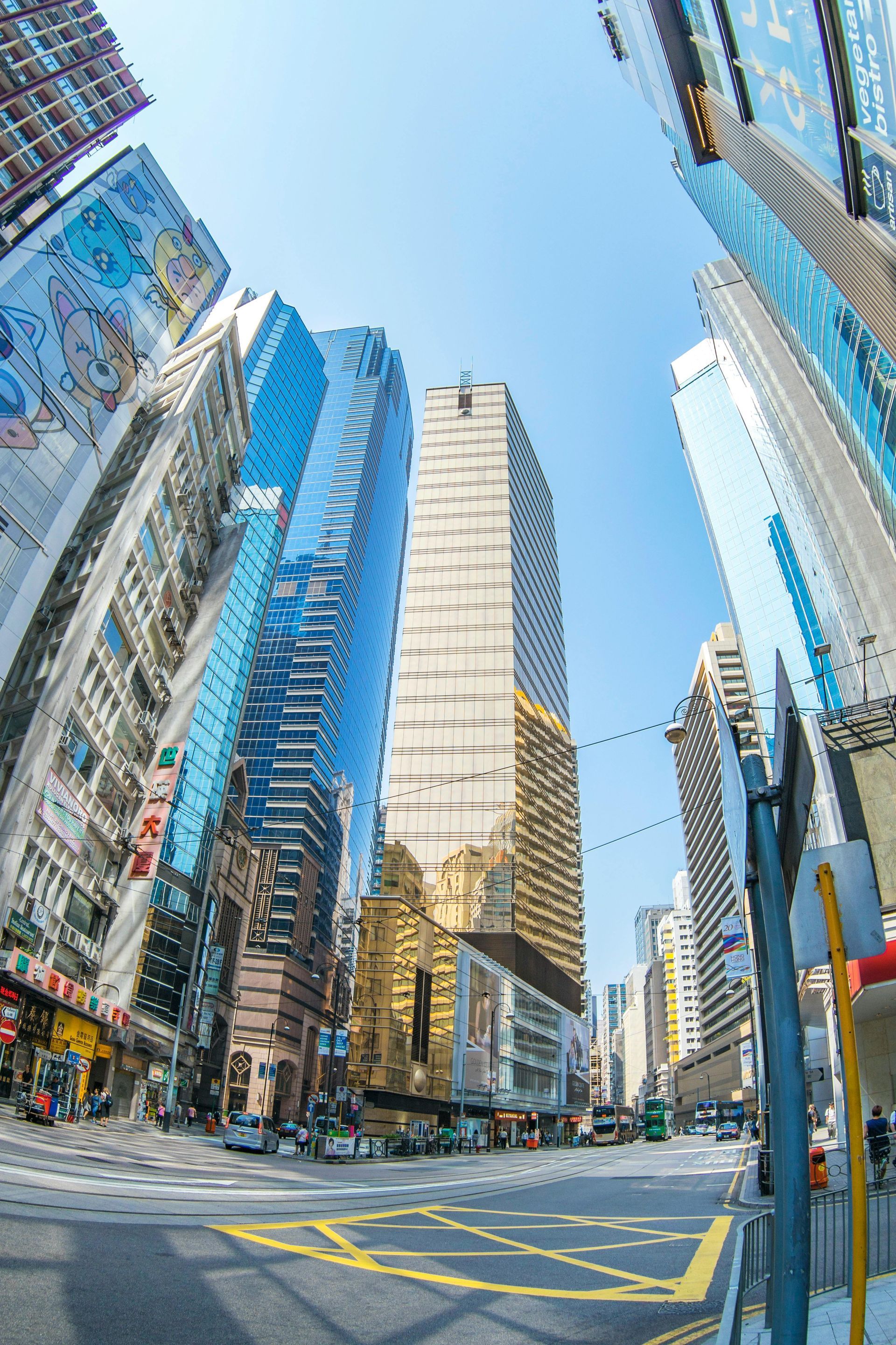 View up a city street towards tall buildings on a sunny day.