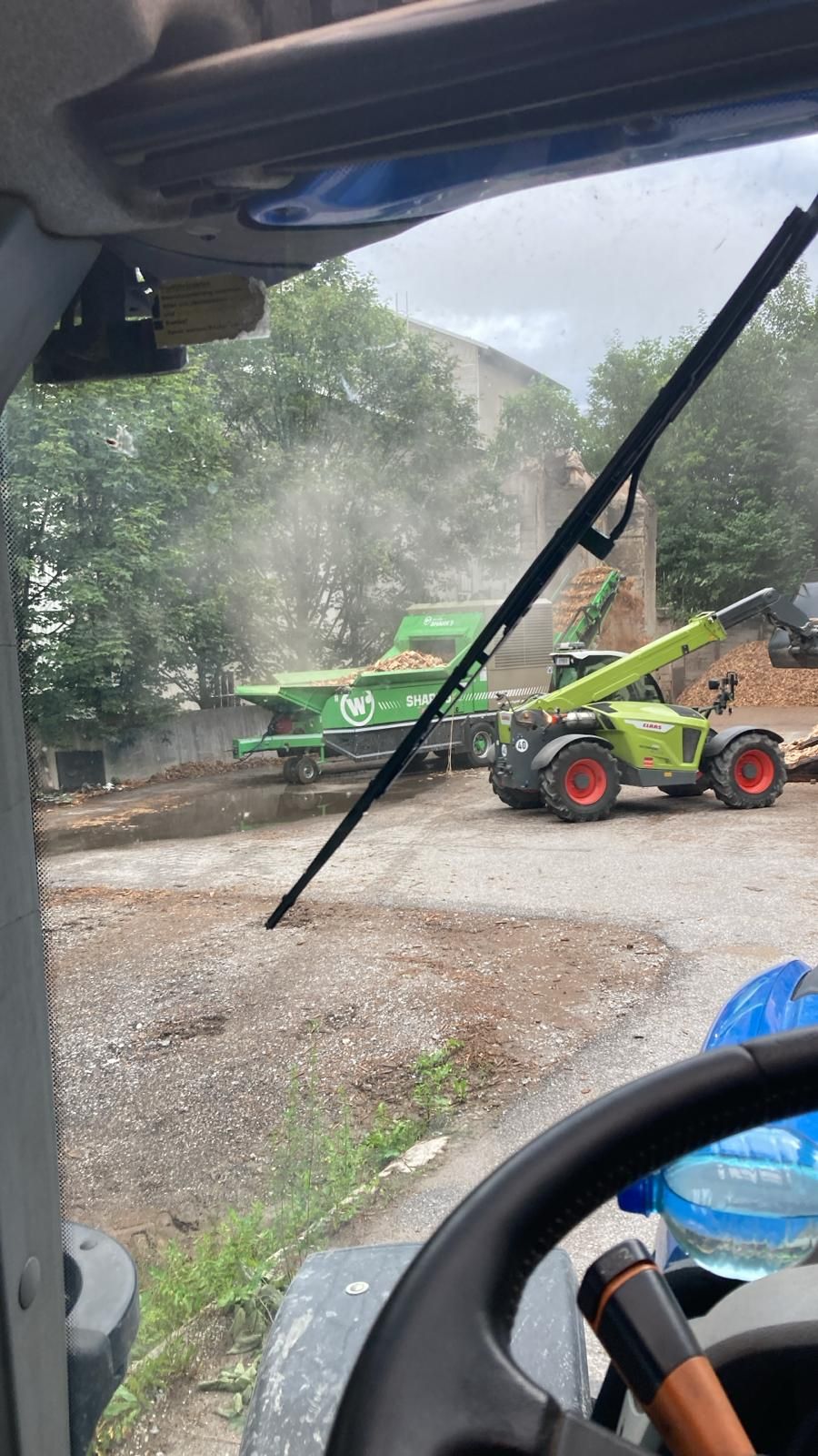 Eine Person fährt einen Traktor auf einem Parkplatz.