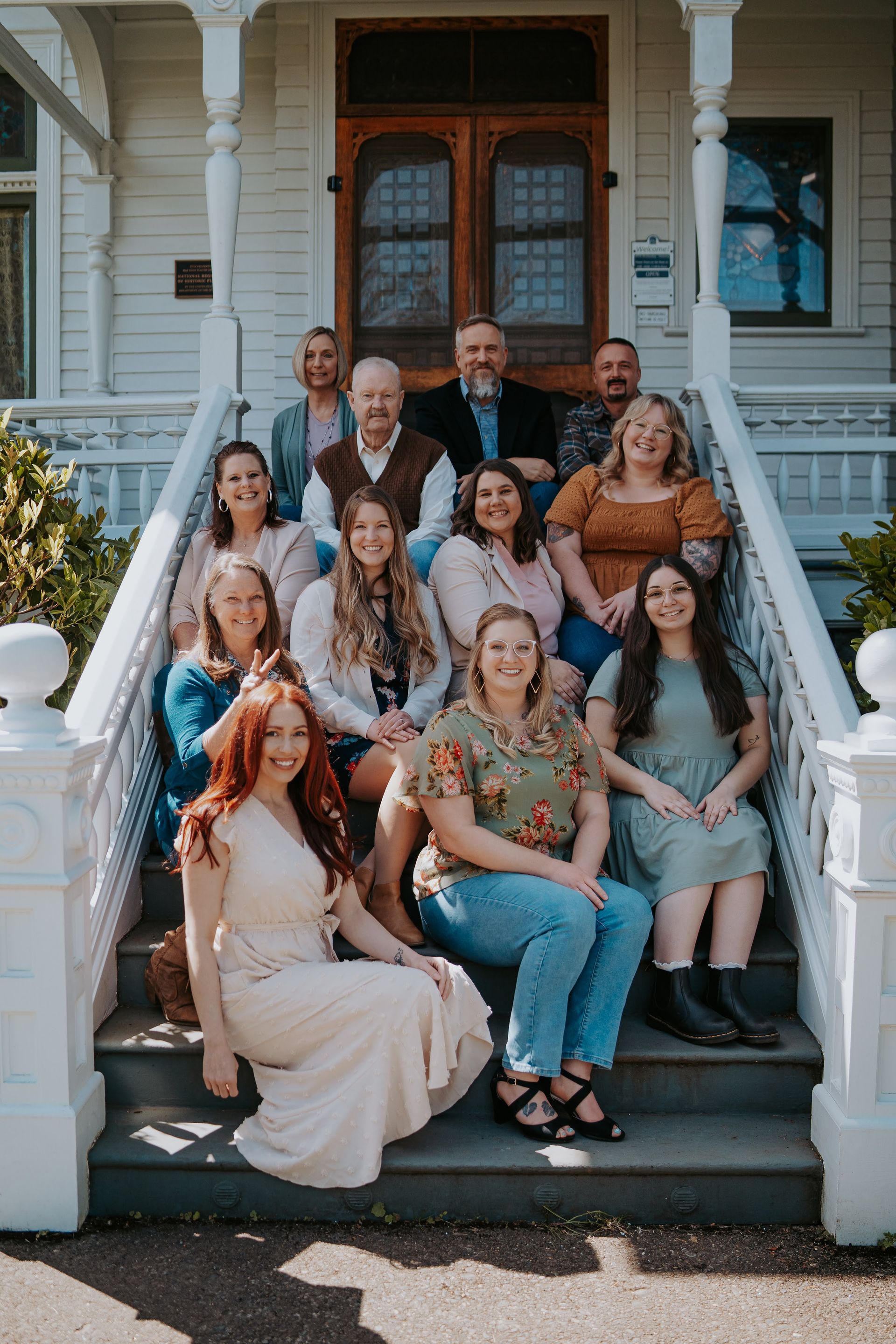 A family is sitting on a bed with a christmas tree in the background.