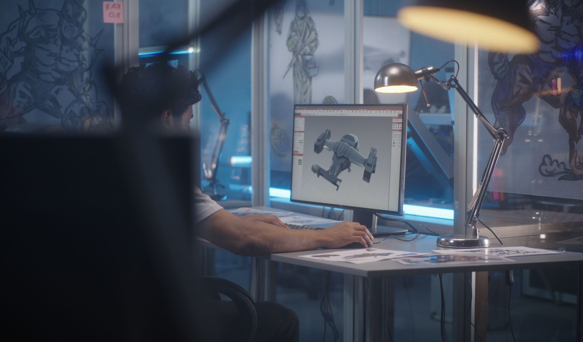A man is sitting at a desk in front of a computer.