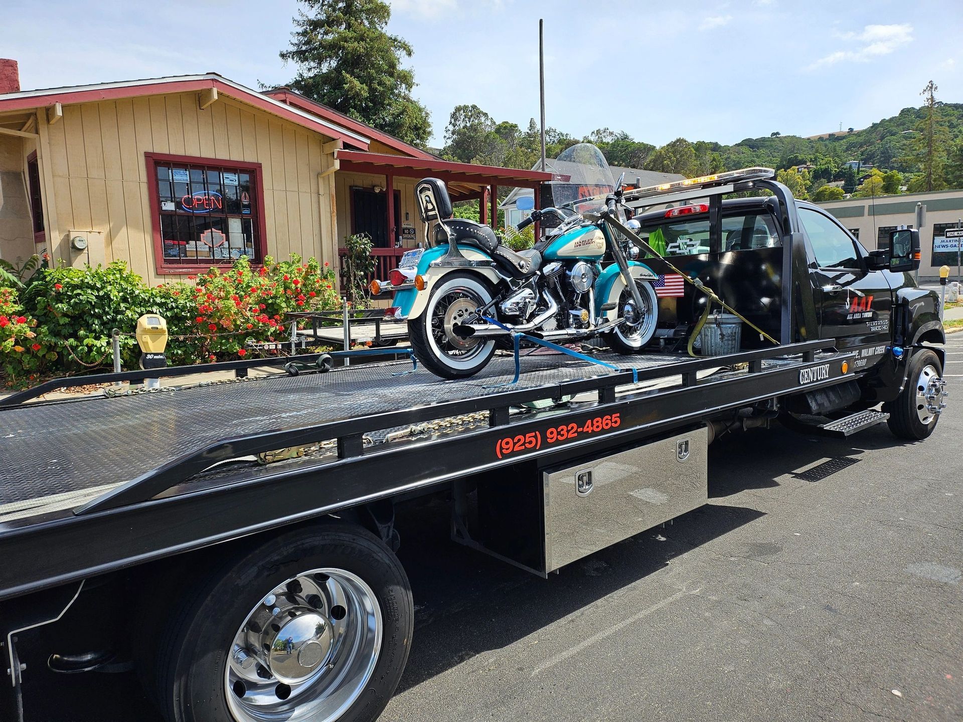 A man is towing a car on a tow truck.