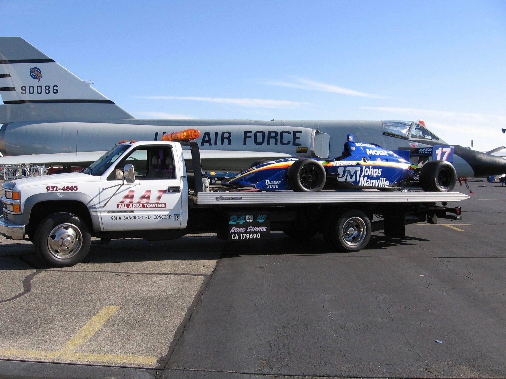 A man is towing a car on a tow truck.