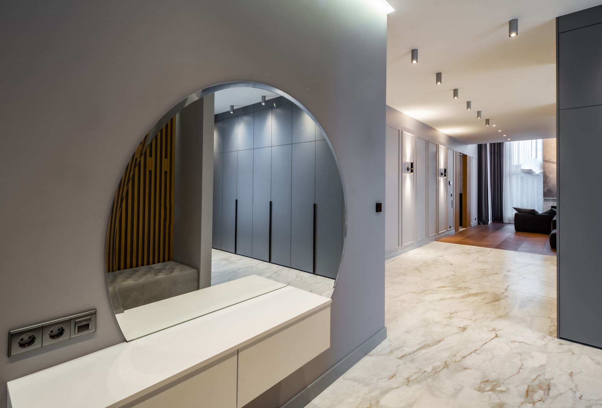 Modern luxury spacious house with mirrored entrance hall and grey-toned living room.