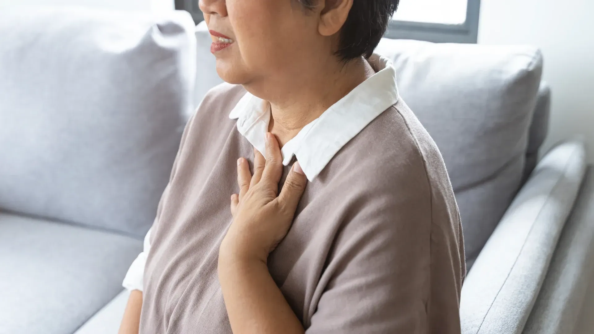 Alt text: Person experiencing chest discomfort related to persistent heartburn