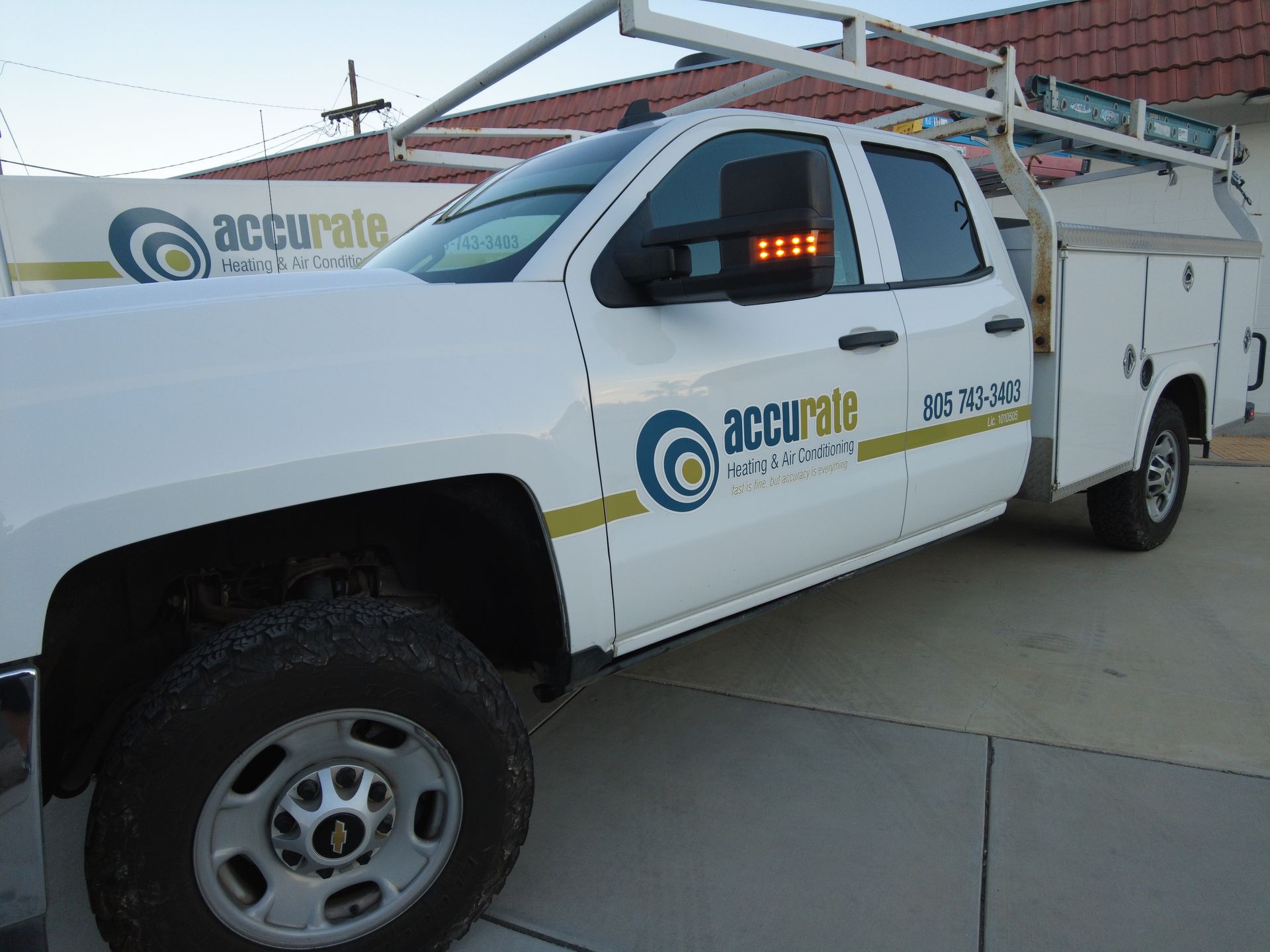Backyard patio with white pergola, outdoor seating, and green grass.