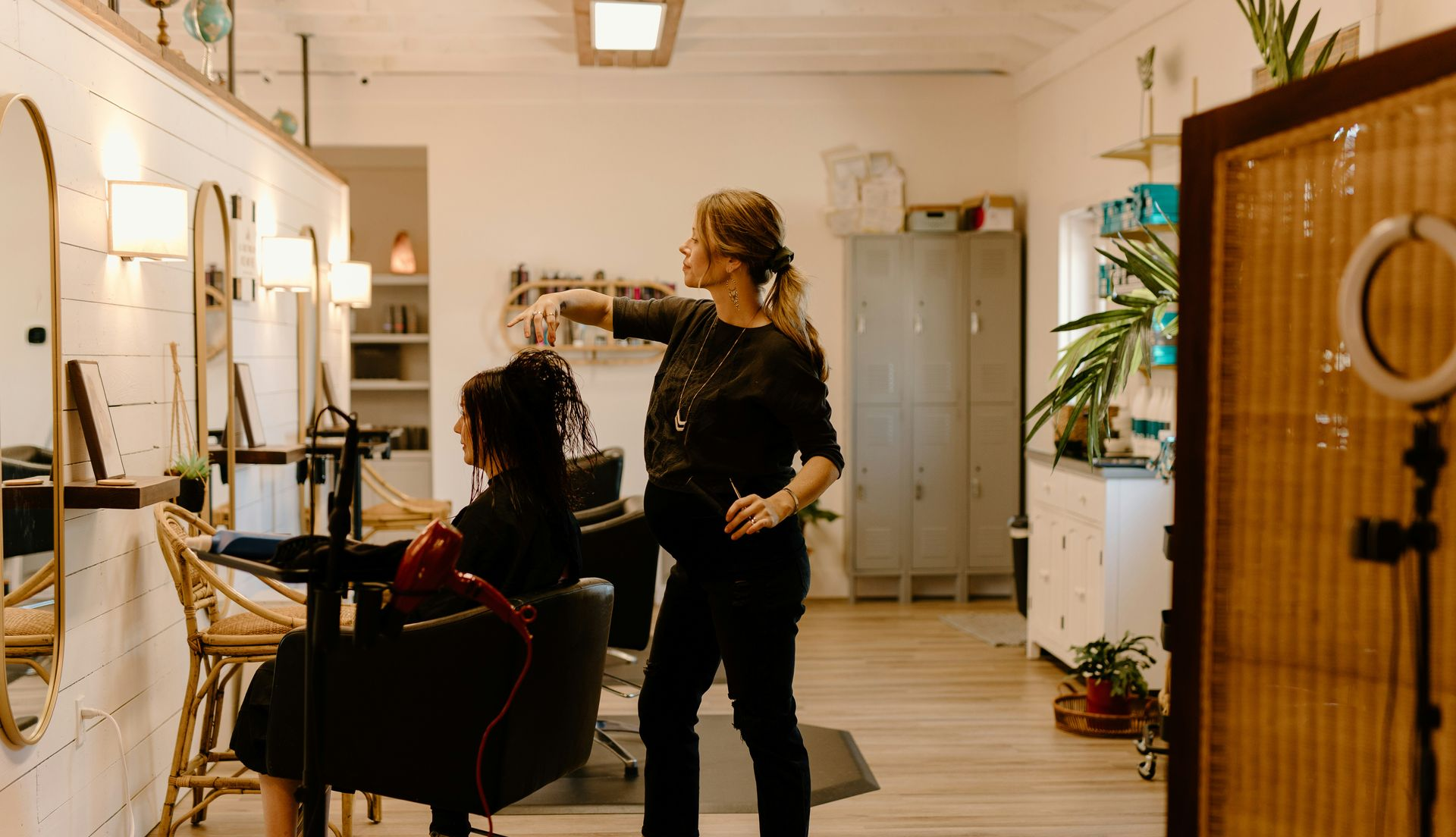 Patio with seating under a slatted pergola, overlooking a grassy backyard.